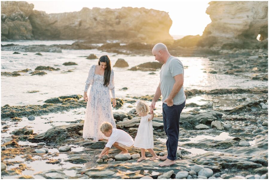 family with 2 toddlers on beach looking at tidepools in Laguna Beach Ca.