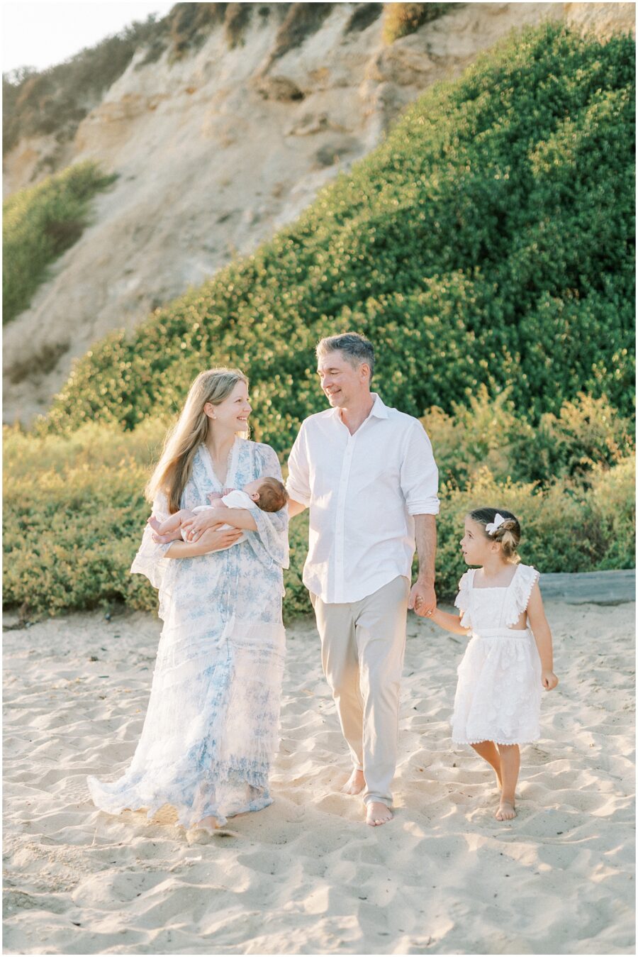 family walking on beach in Newport at sunset