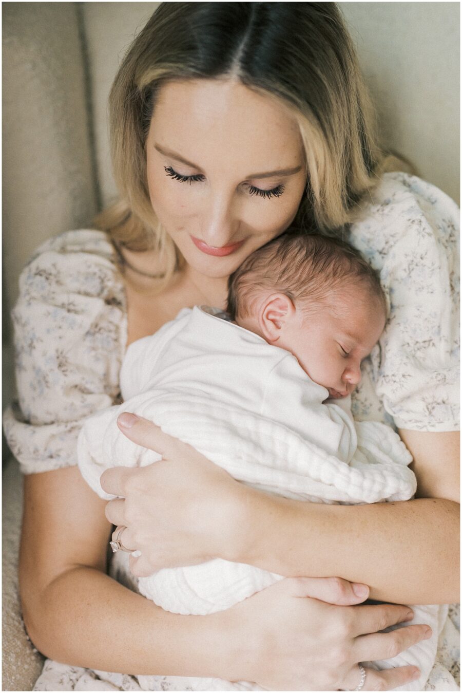 mom snuggling newborn against chest in Orange County 