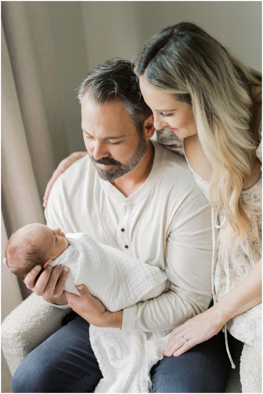 parents holding newborn in swaddle