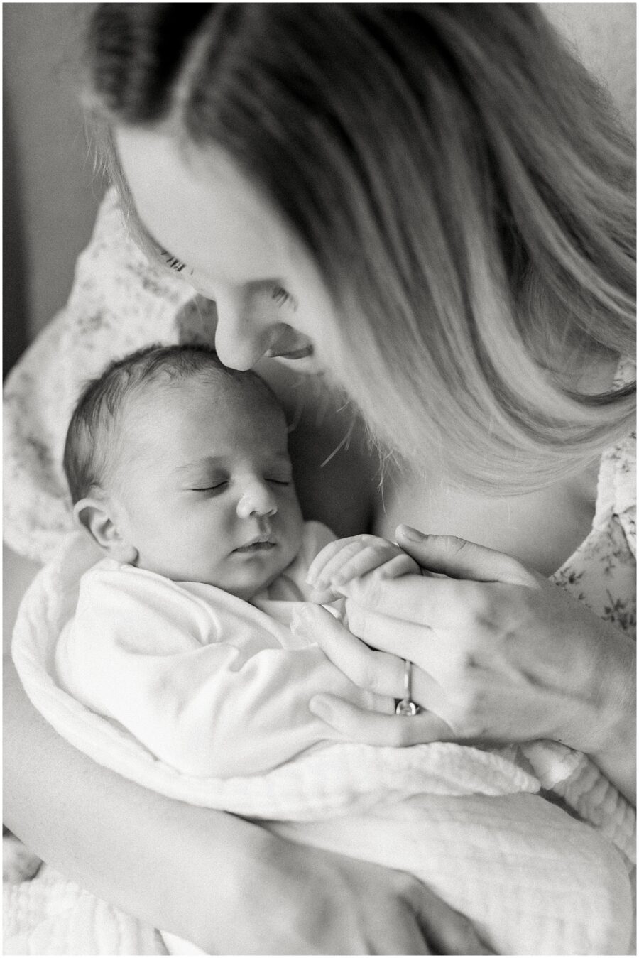 mom holding newborns fingers 